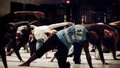 Two dozen bodies crowd the stage as each cast member arches and stretches, breathing deeply...
